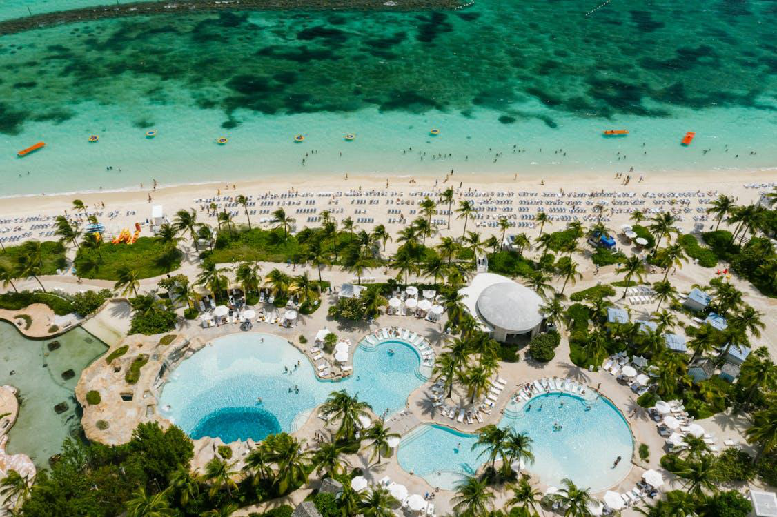 Aerial view of a luxurious beachfront resort with multiple swimming pools