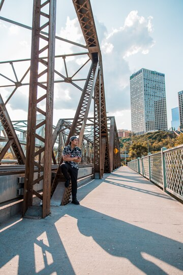 A man standing beside a bridge