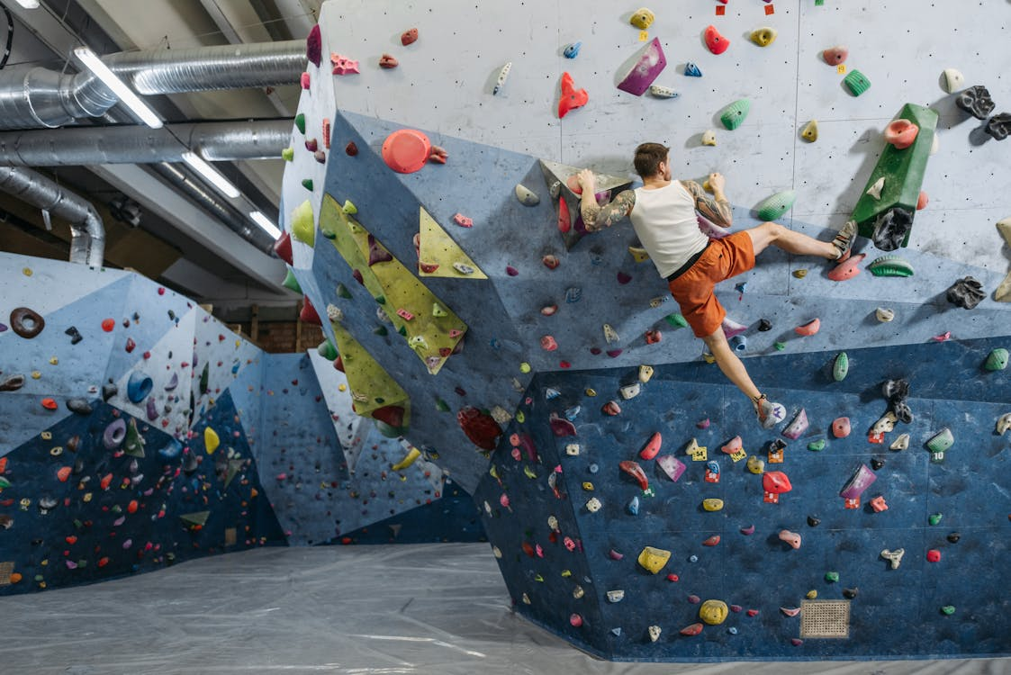 A person in activewear climbing a rock wall