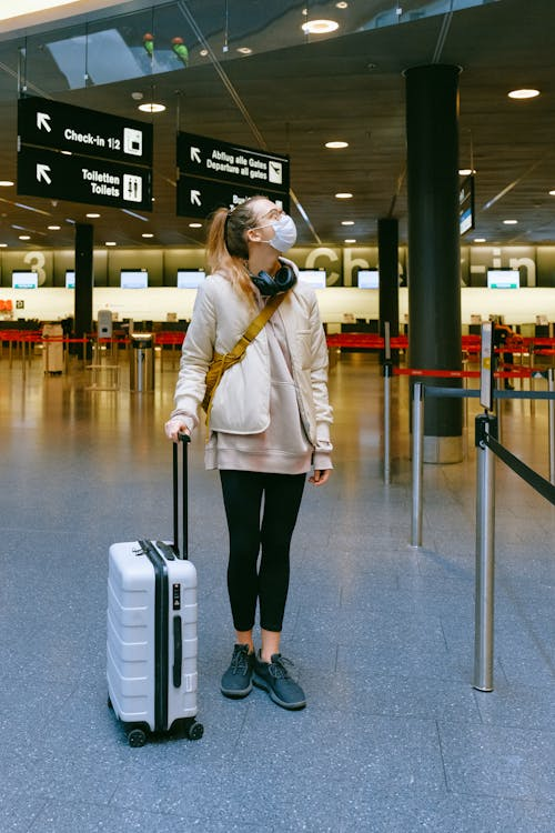 A woman wearing a face mask while waiting at an airport